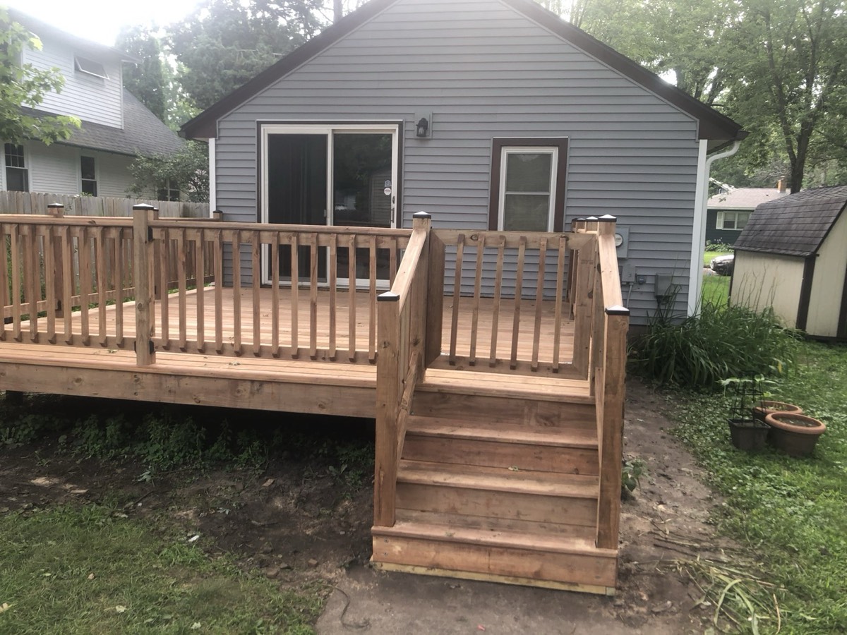 Custom backyard wood deck with railing and stairs built by GR Construction